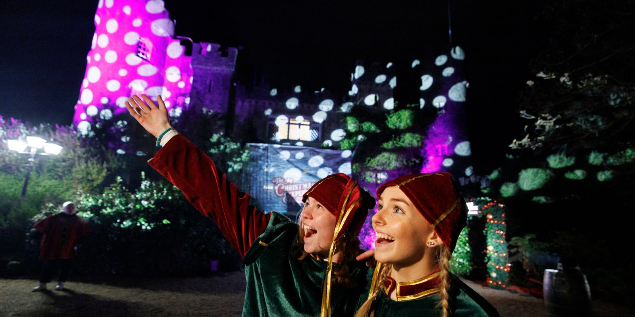 two girls smiling in front of lights